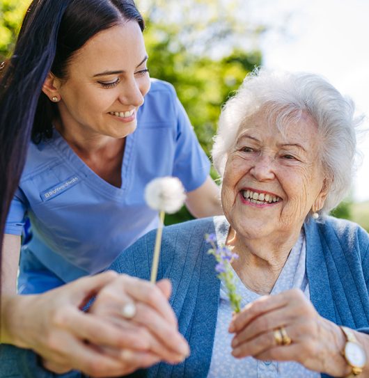 caregiver with woman and flowers caregiver with woman and flowers