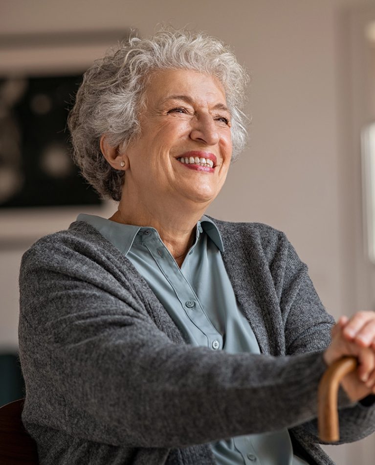 elder woman in grey shirt with cane